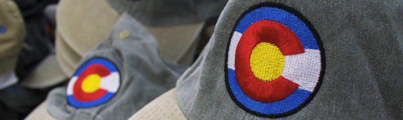 Exquisite hats embroidered with vibrant colors and an intricate Colorado flag design